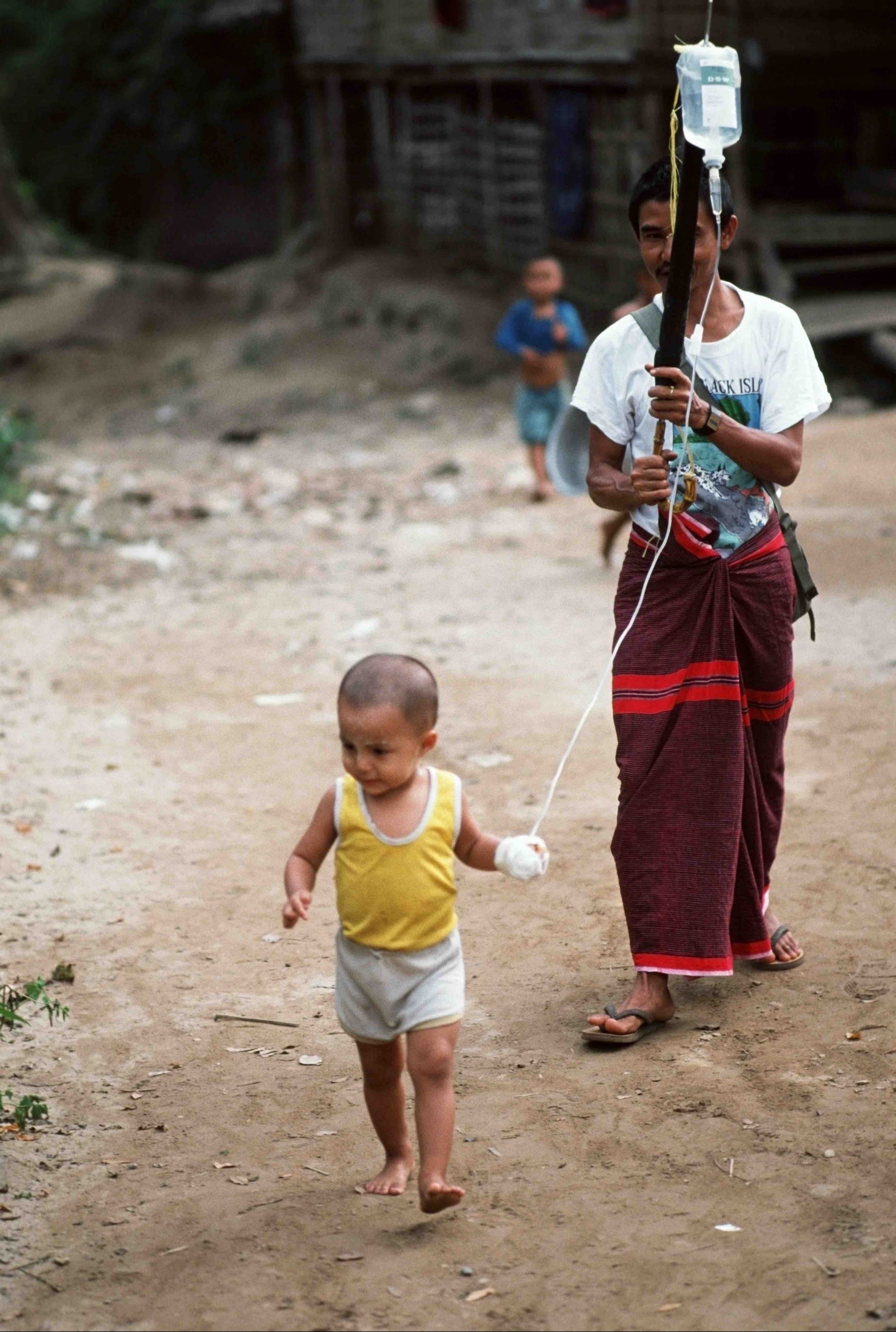 Каренский беженец гуляет со своей дочерью недалеко от тайско-­бирманской границы (1992 г.). ­Девочку выписали из удаленной больницы после лечения малярии